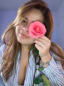 maria luisa about Maria Luisa close shot, covering her left eye with a pink rose